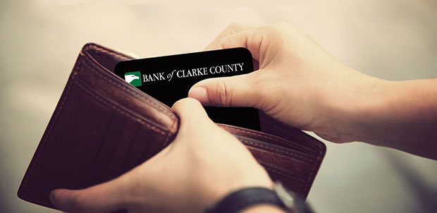 Person taking a Bank of Clarke County debit card out of their wallet