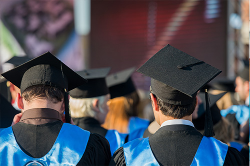 Students wearing caps and gowns at a graduation