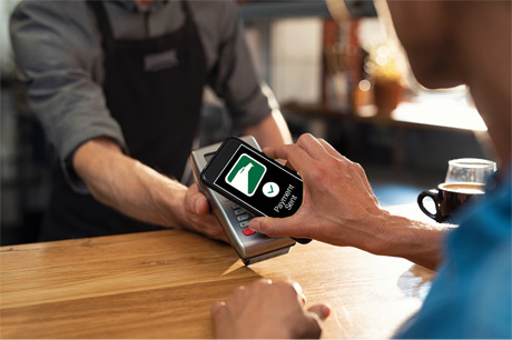 Person using their smartphone to pay at a coffee shop